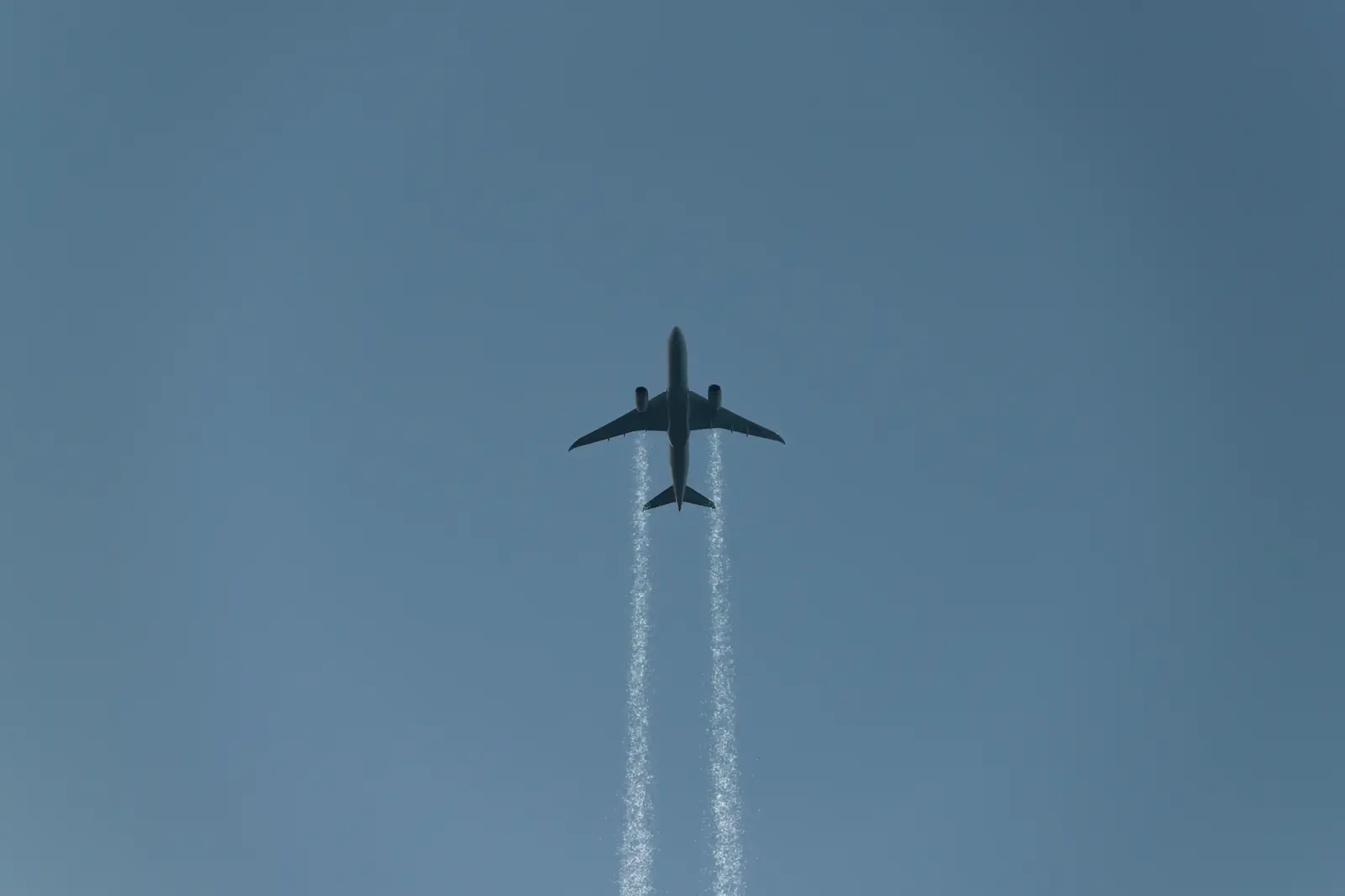 Jet climbing overhead with contrails