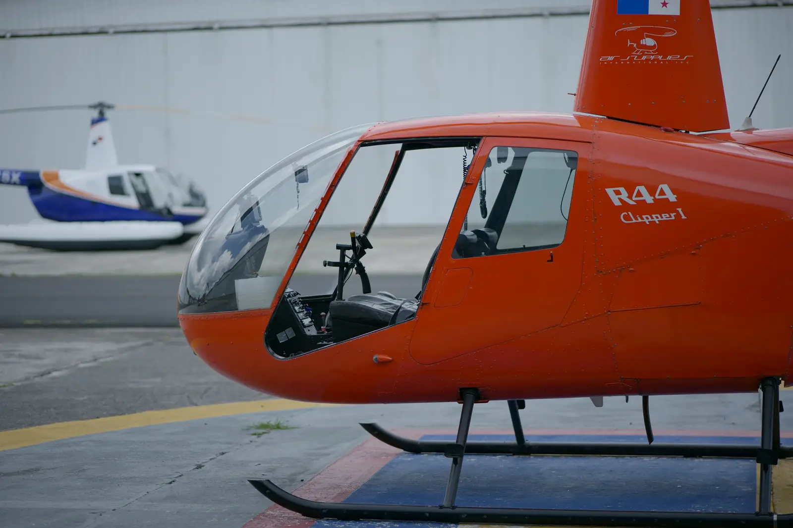 Robinson R44 helicopters on a helipad
